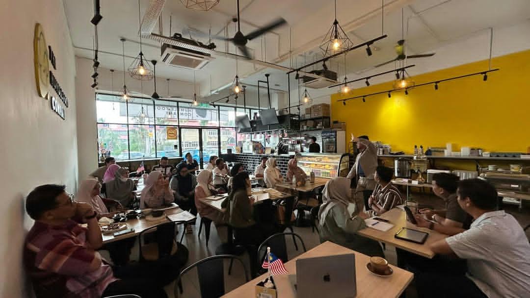 Full cafe workshop, learners at tables with laptops